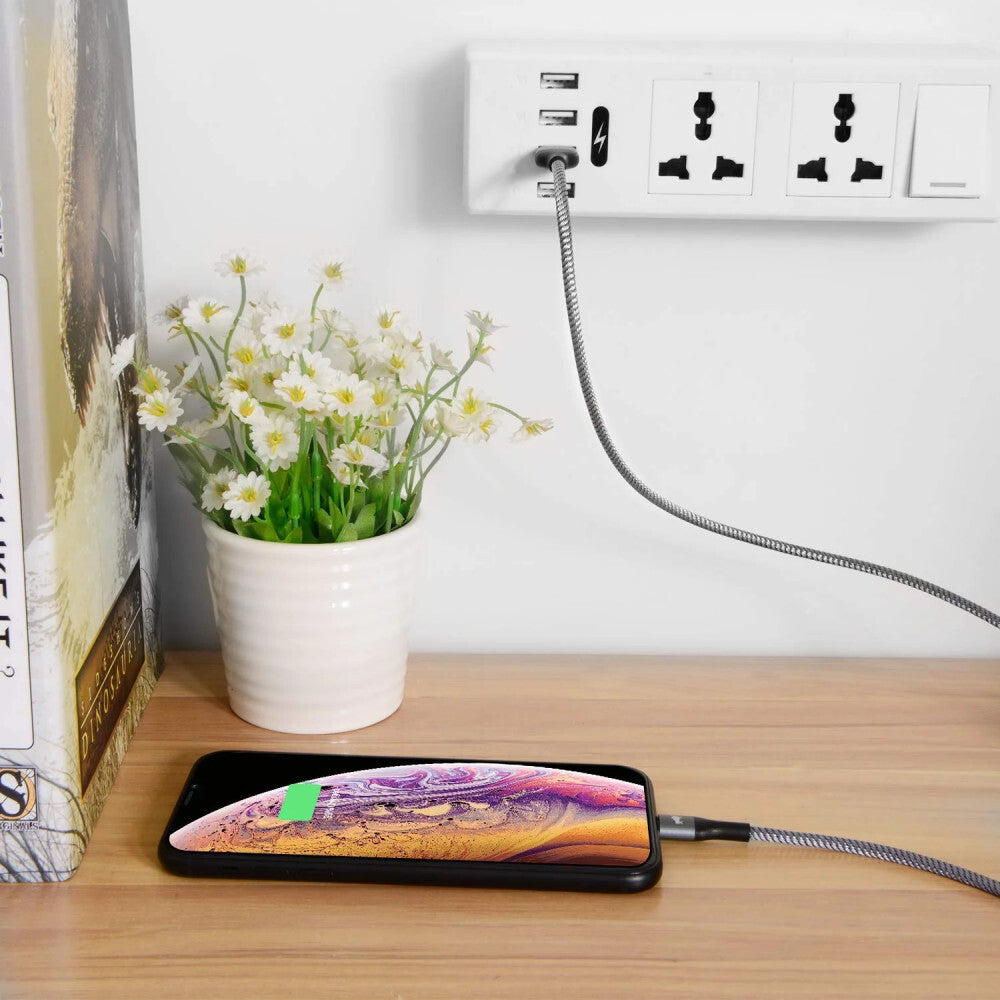 Amoner gyorstöltő kábel fali aljzatba dugva, polcon töltődő iPhone