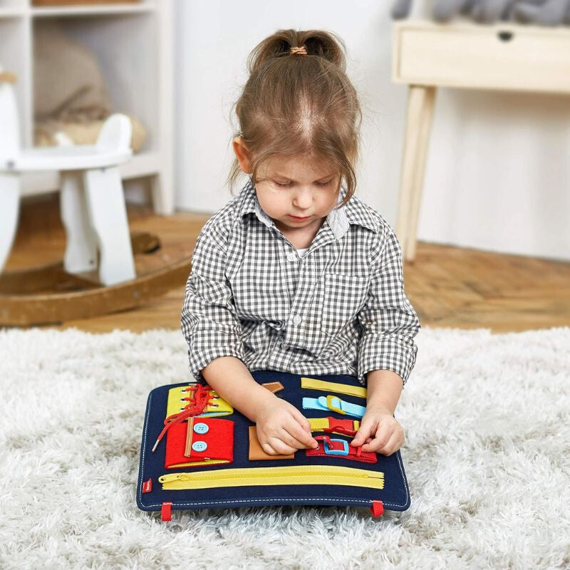Kislány a földön ülve gyakorolja a csatokat a Teaisiy Montessori fejlesztő játékon