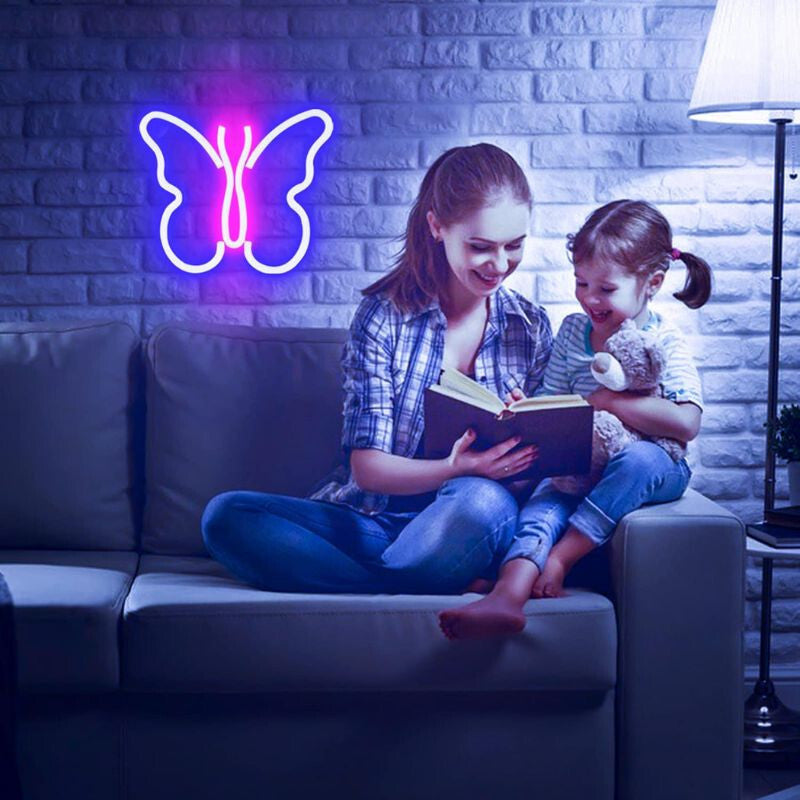 Pillangó LED neon fali dekoráció kanapé felett, alatta anya és kislány olvas